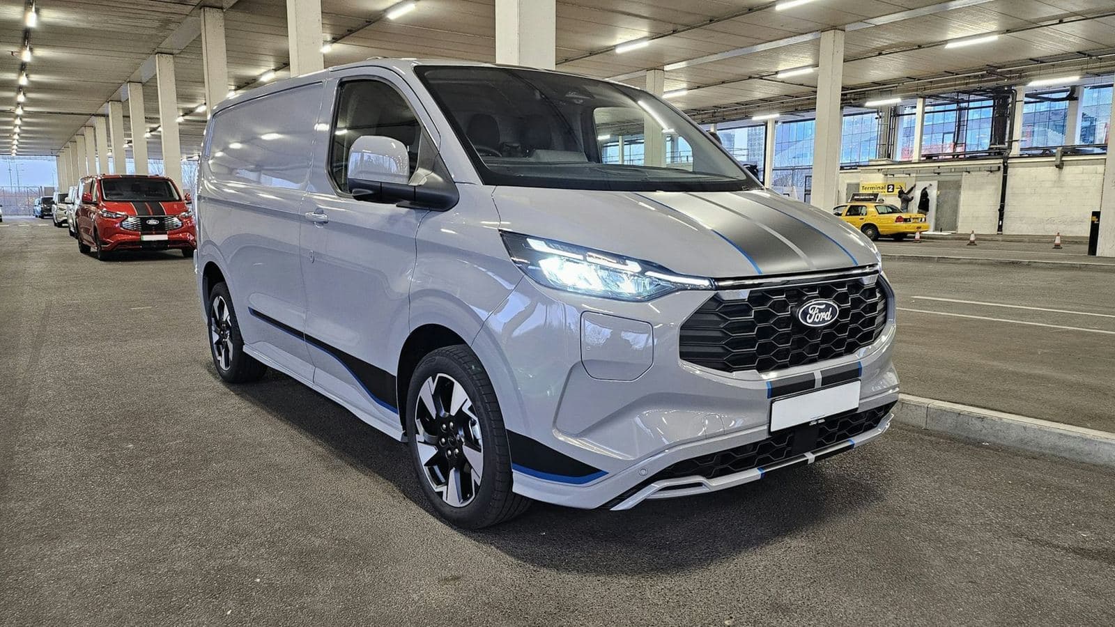 Fourgon utilitaire blanc stationné dans un parking d’entreprise